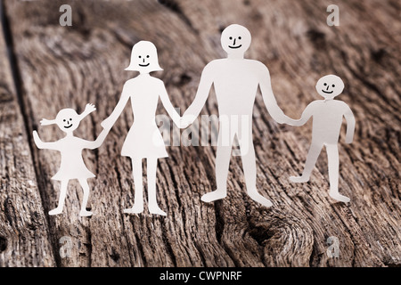 Pappfiguren der Familie auf einem Holztisch. Das Symbol der Einheit und des Glücks. Stockfoto