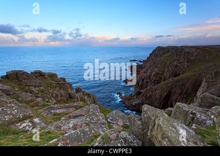 Pordenack Punkt in der Nähe von Lands End in Cornwall Blickrichtung Langschiffe Felsen und den Leuchtturm bei Sonnenaufgang. Stockfoto