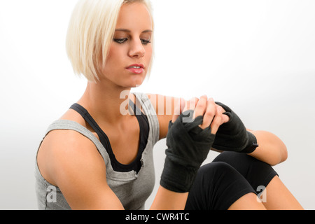 Weibliche Kickboxer Umhüllung Handgelenk in schützenden Bandagen auf weißem Hintergrund Stockfoto