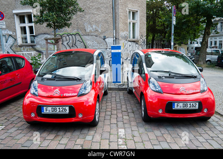 Zwei elektrische Flinkster-Carsharing-Autos Aufladen auf Berliner Straße Deutschland Stockfoto