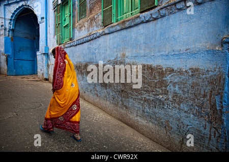 Frau zu Fuß durch eine blau lackierte Gasse. Jodhpur, Rajasthan, Indien Stockfoto