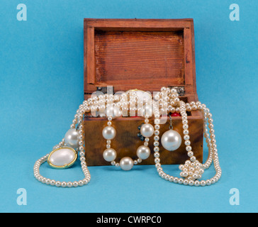 Perlenschmuck Perlen Halskette Ohrring in Retro-Holzkiste auf blauem Hintergrund Stockfoto