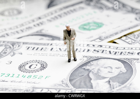 winzige Figur des Kaufmanns stehend auf einem Dollarschein Stockfoto