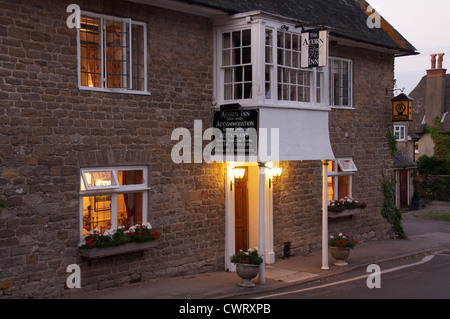 Englische Pubs. Das Acorn Inn in Dorset Dorf von Evershot. Eine Dorfkneipe, Hotel und Restaurant, seine freundlichen Lichter leuchten am Abend. England. Stockfoto