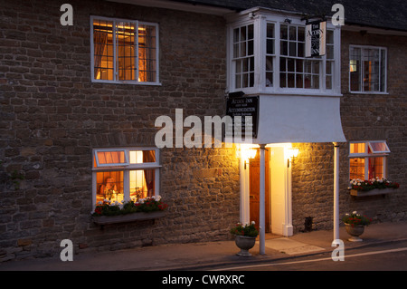 Englische Pubs. Das Acorn Inn in Dorset Dorf von Evershot. Eine Dorfkneipe, Hotel und Restaurant, seine freundlichen Lichter leuchten am Abend. England. Stockfoto