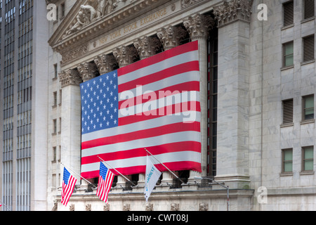 Die neoklassischen New Yorker Börse an der Wall Street in New York City eine große amerikanische Flagge anzeigen. Stockfoto