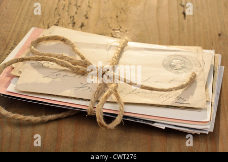 Bündel von Briefen, die mit einer Schnur auf dem alten Holztisch gebunden Stockfoto