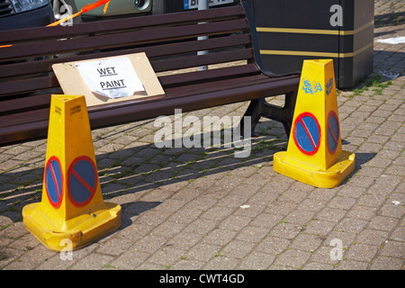 Nass malen Zeichen auf Bank mit zwei Leitkegel Kontrolle stoppen Menschen zu nah dran am Kai in Weymouth im Mai Stockfoto