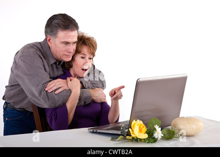 Ein älteres paar gelesen, dass etwas die Frau auf ihren Laptop-Bildschirm überraschend findet. Stockfoto