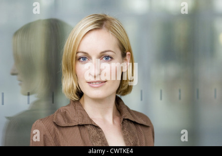 Lächelnde junge Frau tragen braune Bluse, portrait Stockfoto