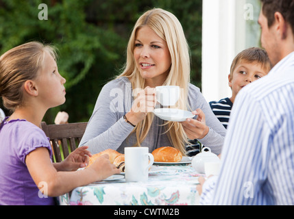 Familie mit zwei Kindern frühstücken auf der Terrasse Stockfoto