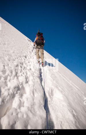 Ein Bergsteiger besteigt den steilen Hang bis auf den Grat, der Sie auf den Gipfel des Weissmies in den Alpen führt. Stockfoto