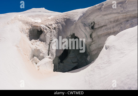 Schauen tief in eine Gletscherspalte beim Überqueren einer versunkenen Schnee-Brücke auf der Abfahrt vom Weissmies. Saas Grund der Schweiz. Stockfoto