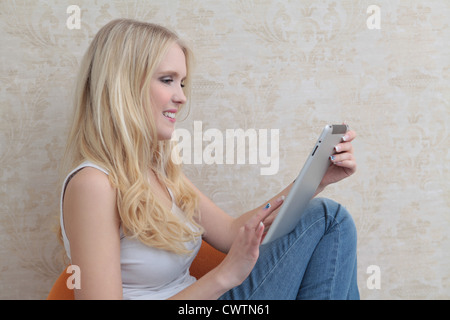 Glückliche junge Frau mit Tablet-PC Stockfoto