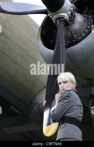 Junge Frau am Propeller-Flugzeug Stockfoto