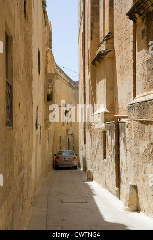 Gasse in der "stillen Stadt" Mdina, Malta, wo ein Auto zwischen den Gebäuden geht Stockfoto