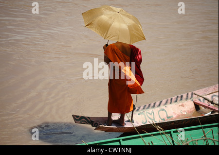 Mönch mit Regenschirm Kanu auf dem Fluss Nam Khan in Luang Prabang, Laos. Stockfoto