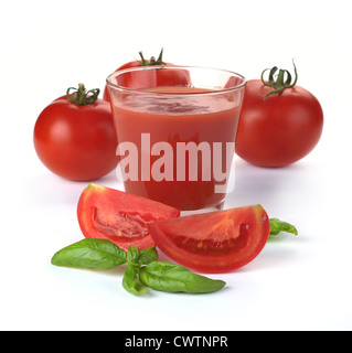 Glas Tomatensaft und Früchte mit grünen Blättern, die isoliert auf weiss Stockfoto