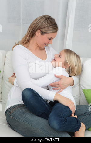 Mutter und Tochter kuscheln auf couch Stockfoto