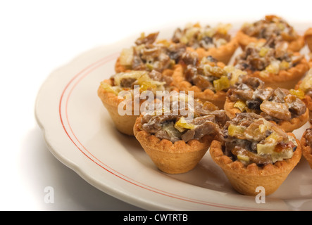 Mini-Törtchen mit Champignons, Käse und Gemüse auf weißen Teller Stockfoto