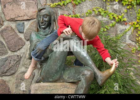 junge Boying sitzen auf der Statue von Till Eulenspiegel, Mölln, Schleswig-Holstein, Deutschland Stockfoto