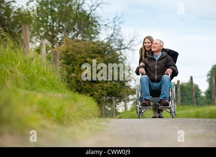 Frau drängen Vater im Rollstuhl Stockfoto