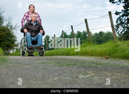 Frau drängen Vater im Rollstuhl Stockfoto