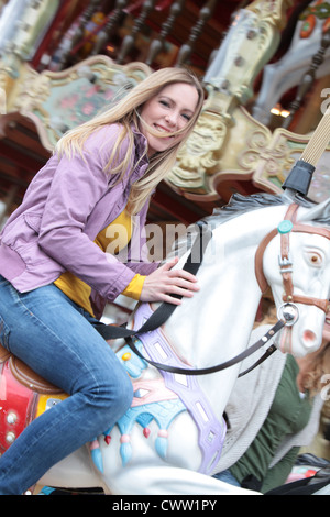 Glückliche Frau auf einem Karussell Stockfoto