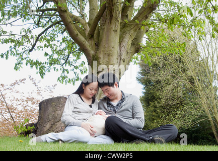 Eltern halten schlafendes Baby im park Stockfoto