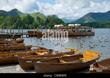 Menschen Touristen Besucher auf Startboot Ruderboote auf Derwentwater Mit Catbells im Hintergrund im Sommer Keswick Cumbria England Vereinigtes Königreich Stockfoto