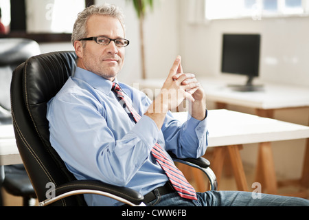 Lächelnde Geschäftsmann am Schreibtisch Stockfoto