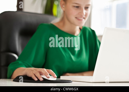 Geschäftsfrau, die Arbeiten am Laptop an der Rezeption Stockfoto