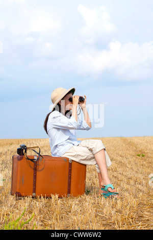9 Jahre reisen Mädchen im Feld erntete mit alten Reisetasche. Stockfoto