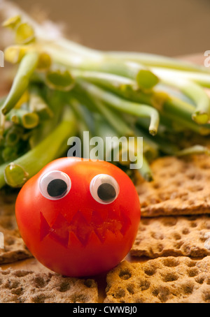 Wütend Tomate sitzt auf einem Bett von ryevita Stockfoto