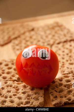 Wütend Tomate sitzt auf einem Bett von ryevita Stockfoto