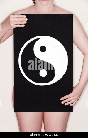 Frau hält eine Tafel mit einem Yin-Yang-Symbol drauf in Kreide gezeichnet. Konzept-Bild Stockfoto