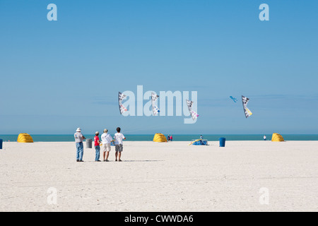 Vier Männer demonstrieren synchronisiertes Fliegen auf St. Pete Beach beim Treasure Island Kite Festival in Treasure Island, Florida Stockfoto