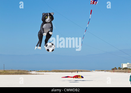 Kite geformt wie eine Katze und ein Fußball fliegt über Strand auf der Schatzinsel Kite Festival in Treasure Island, Florida Stockfoto