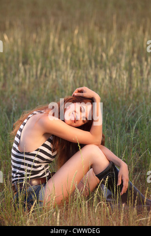 Frau sitzt auf Wiese Stockfoto