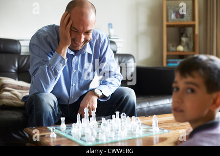 Vater und Sohn zusammen spielen Schach Stockfoto