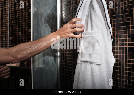 Mann Griff nach Bademantel in Dusche Stockfoto