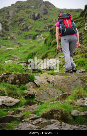 Ein Wanderer Ansätze Taube Crag auf einem steilen Pfad im Lake District, Cumbria. Stockfoto