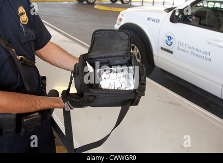 US Customs and Border Protection Officer hält Tasche enthält ein Paket von Marihuana zu trainieren Hunde zu schnuppern und Drogen zu finden Stockfoto