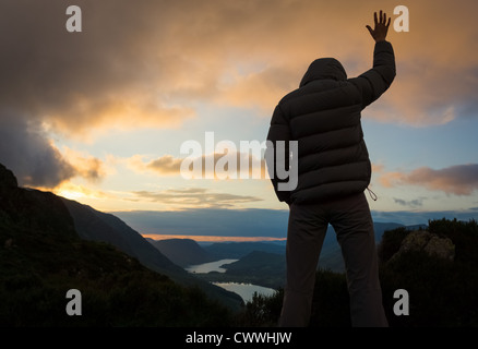 Eine Frau, die vom Gipfel eines Berges verehren. Stockfoto
