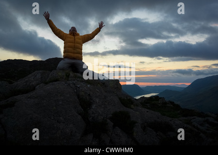 Ein Mann verehren Gott vom Gipfel eines Berges. Stockfoto