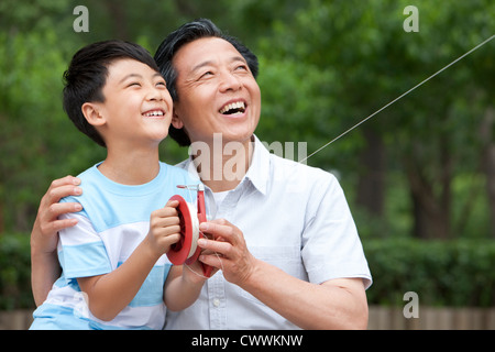 Großvater und Enkel gemeinsam einen Drachen fliegen Stockfoto