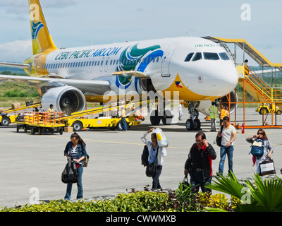 Gensan, Philippinen - 2. April 2011: Steigen Sie Reisenden nach der Landung in Gensan an einem sehr heißen Tag, während der Flughafen Cebu Pacific Air Stockfoto