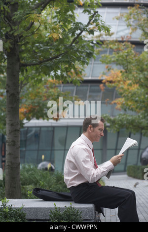 Geschäftsmann lesen Zeitung im park Stockfoto