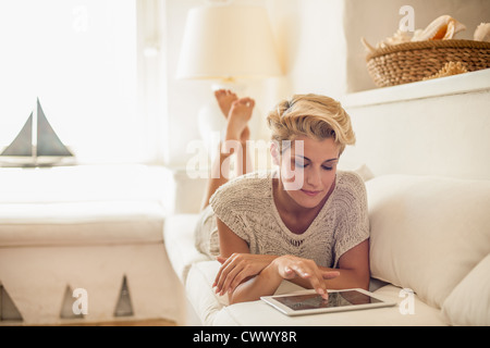 Frau mit Tablet-PC auf sofa Stockfoto