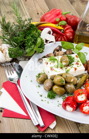 Gemischte Antipasti auf einer Platte gegen Holz Stockfoto